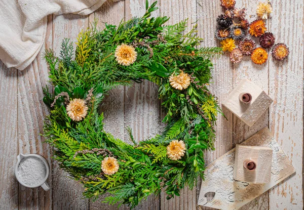 Noel tatili için ev yapımı ahşap evlerle doğal çelenk.