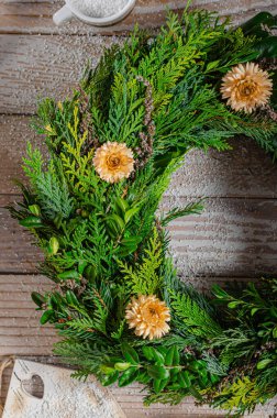 Noel tatili için ev yapımı ahşap evlerle doğal çelenk.