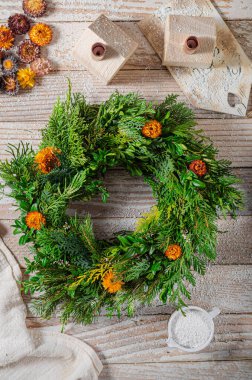 Noel tatili için ev yapımı ahşap evlerle doğal çelenk.