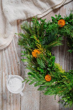 Noel tatili için ev yapımı ahşap evlerle doğal çelenk.