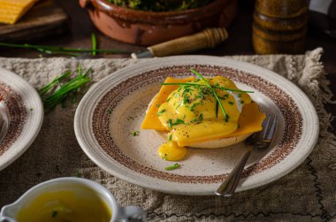 Domuz pastırmalı, çedar peynirli, otlu ve hollandaise soslu organik yumurta.