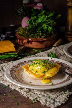 Domuz pastırmalı, çedar peynirli, otlu ve hollandaise soslu organik yumurta.