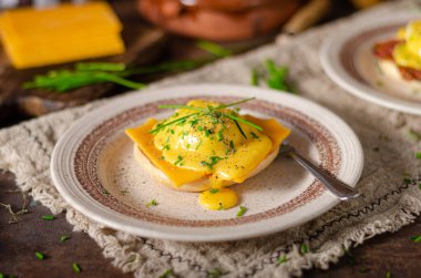 Domuz pastırmalı, çedar peynirli, otlu ve hollandaise soslu organik yumurta.