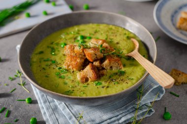 Lezzetli sızıntı çorbası, taze bezelye ve kızarmış ekmek.