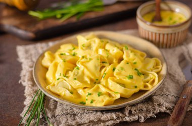 Lezzetli çedar soslu ve otlu ev yapımı tortellini.