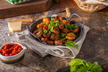 Kızarmış mantar ve bitkilerle kaplı kırmızı biber sosu.