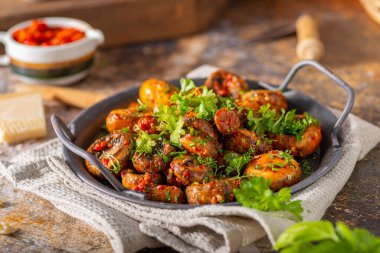 Kızarmış mantar ve bitkilerle kaplı kırmızı biber sosu.