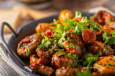 Kızarmış mantar ve bitkilerle kaplı kırmızı biber sosu.