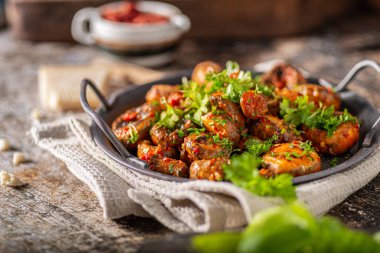 Kızarmış mantar ve bitkilerle kaplı kırmızı biber sosu.