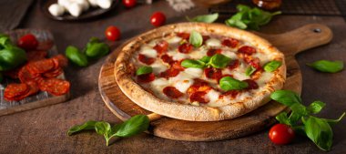 Sıcak salamlı, parmesanlı ve taze fesleğenli lezzetli pizza.