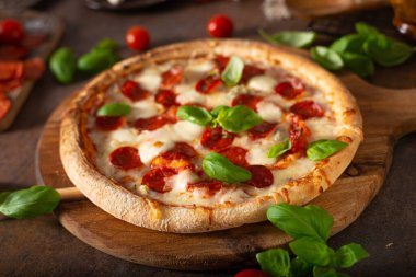 Sıcak salamlı, parmesanlı ve taze fesleğenli lezzetli pizza.