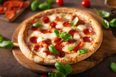 Sıcak salamlı, parmesanlı ve taze fesleğenli lezzetli pizza.