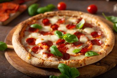 Sıcak salamlı, parmesanlı ve taze fesleğenli lezzetli pizza.