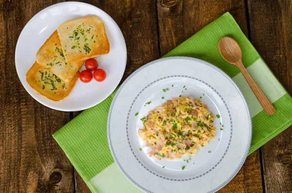 Scrambled eggs with chive and bacon, toast with herbs — Stock Photo, Image