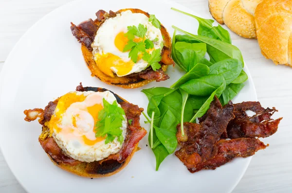 Eggs benedict with bacon and spinach — Stock Photo, Image