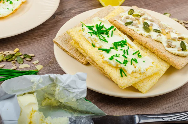 Τραγανό ψωμί τύπου φρυγανιάς με τυρί εξάπλωση με σχοινόπρασο και τραγανό ψωμί τύπου φρυγανιάς με τυρί εξάπλωση σχοινόπρασο και σπόροι — Φωτογραφία Αρχείου