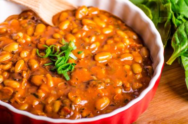 Spicy cowboy beans with hassleback potatoe with herbs clipart
