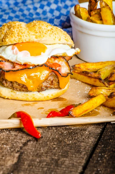 Hamburger fatto in casa con uovo fritto e patatine fritte piccanti — Foto Stock