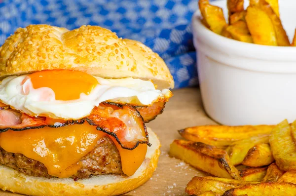 Hamburger fatto in casa con uovo fritto e patatine fritte piccanti — Foto Stock
