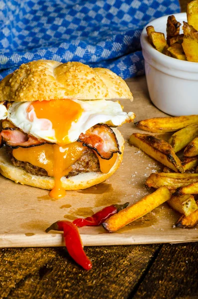 Homemade burger with fried egg and spicy fries — Stock Photo, Image