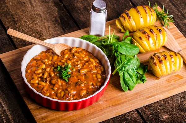 Spicy cowboy beans with hassleback potatoe with herbs — Stock Photo, Image