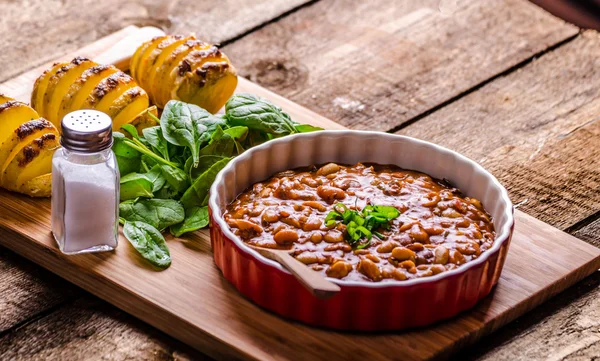 Spicy cowboy beans with hassleback potatoe with herbs — Stock Photo, Image