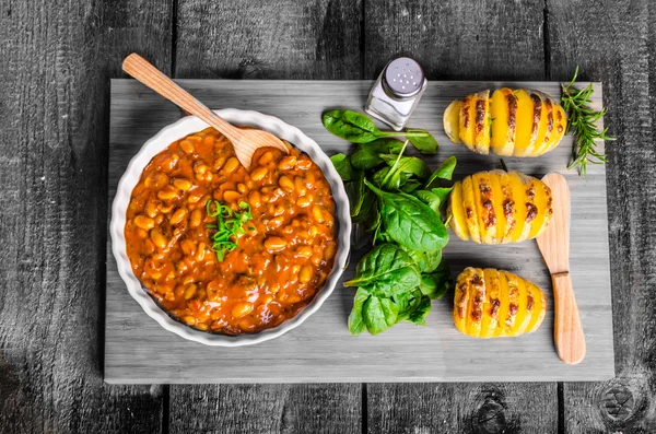 Spicy cowboy beans with hassleback potatoe with herbs — Stock Image Spicy cowboy beans with hassleback potatoe with herbs Stock Photo