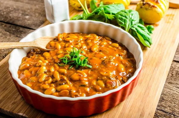 Spicy cowboy beans with hassleback potatoe with herbs — Stock Image Spicy cowboy beans with hassleback potatoe with herbs Royalty Free Stock Images