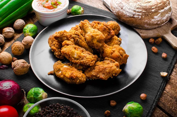 Spicy breaded chicken wings with homemade bread — Stock Photo, Image
