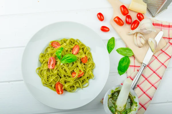 Spenat tagliatelle med basilikapesto och mini tomater — Stockfoto