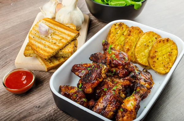 Sticky chicken wings with garlic panini bread — Stock Photo, Image