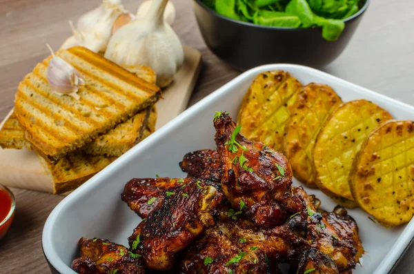 Sticky chicken wings with garlic panini bread — Stock Photo, Image
