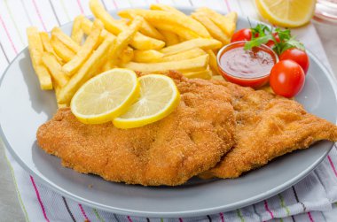 Schnitzel with french fries and a spicy dip clipart