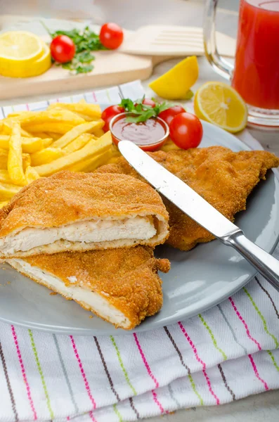 Schnitzel met patat en een pittige duik — Stockfoto