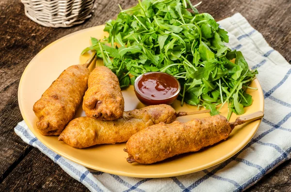 Corn dog with fresh arugula salad and hot dip — Stock Photo, Image