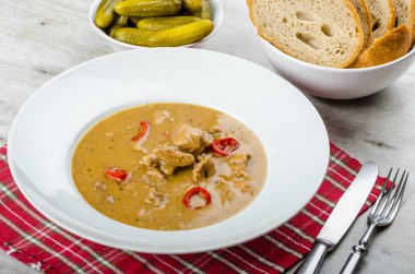 Pork stew and homemade bread and pickles clipart