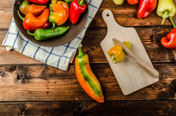 Slicing peppers with wood knife — Stock Photo, Image