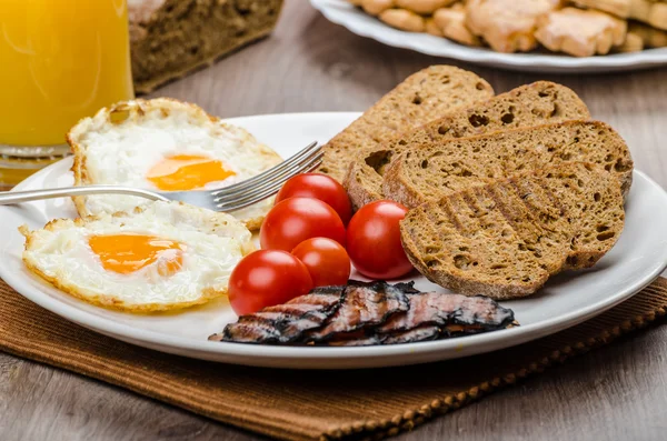 Frühstück - Speck, Wurst, Brot und Eier — Stockfoto