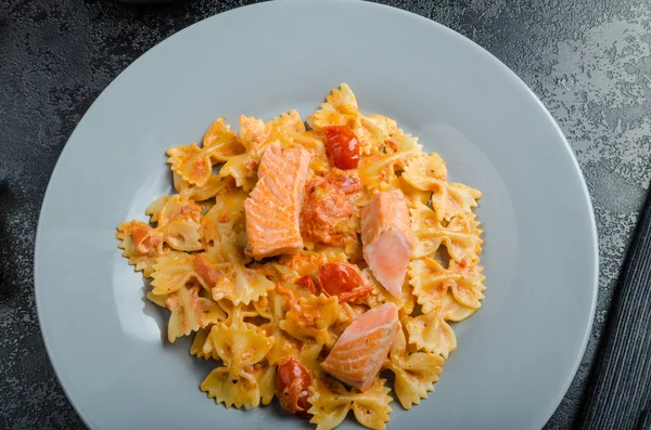 Farfalle with tomato sauce and roasted salmon — Stock Photo, Image