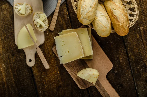 Вкусный спелый сыр с хрустящим багетом и вином — стоковое фото