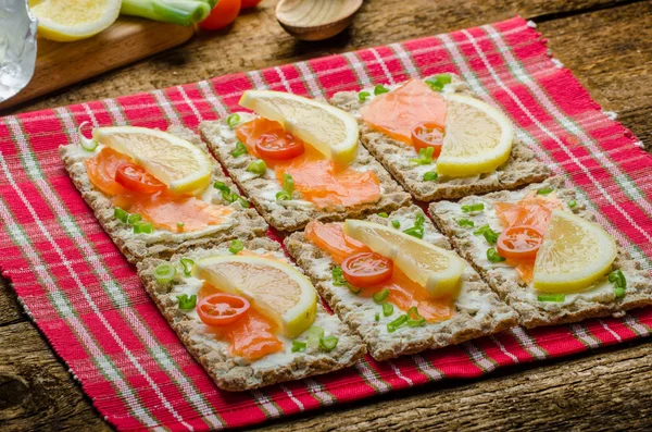 Biyo sağlıklı gıda - kneckebrot peynir füme somon ve kiraz domates ile yayıldı. — Stok fotoğraf