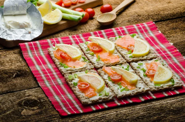 Bio alimentos saludables - kneckebrot queso untado con salmón ahumado y tomates cherry — Foto de Stock