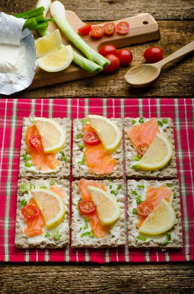 Bio alimentos saludables - kneckebrot queso untado con salmón ahumado y tomates cherry —  Fotos de Stock