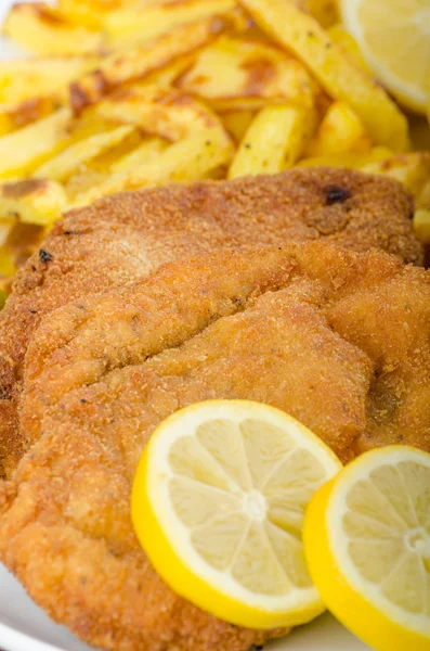 Big Chicken schnitzel with homemade chilli french fries Stock Picture