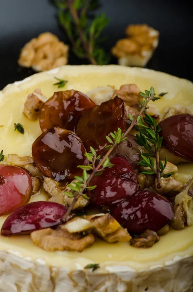 Queso brie al horno con frutos secos y uvas —  Fotos de Stock