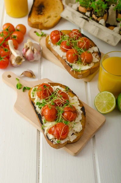 Molho de tomate cereja torrado e ricota em torradas — Fotografia de Stock