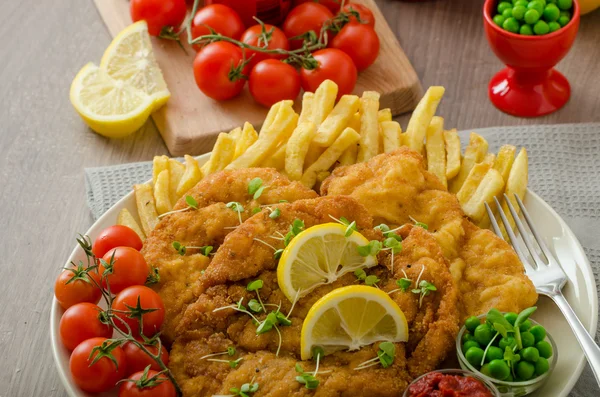 Schnitzel, french fries and microgreens salad — Stock Photo, Image