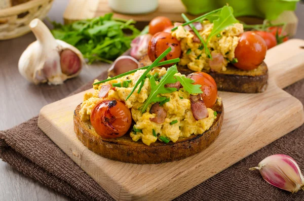 Scrambled eggs witch bacon, herbs and tomato — Stock Photo, Image