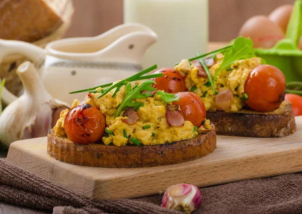 Eggerøre, heksebacon, urter og tomat – stockfoto