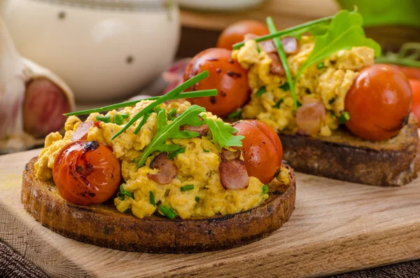 Scrambled eggs witch bacon, herbs and tomato — Stock Photo, Image